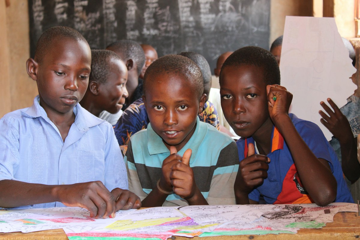 Young pupils drawing together at a classroom table