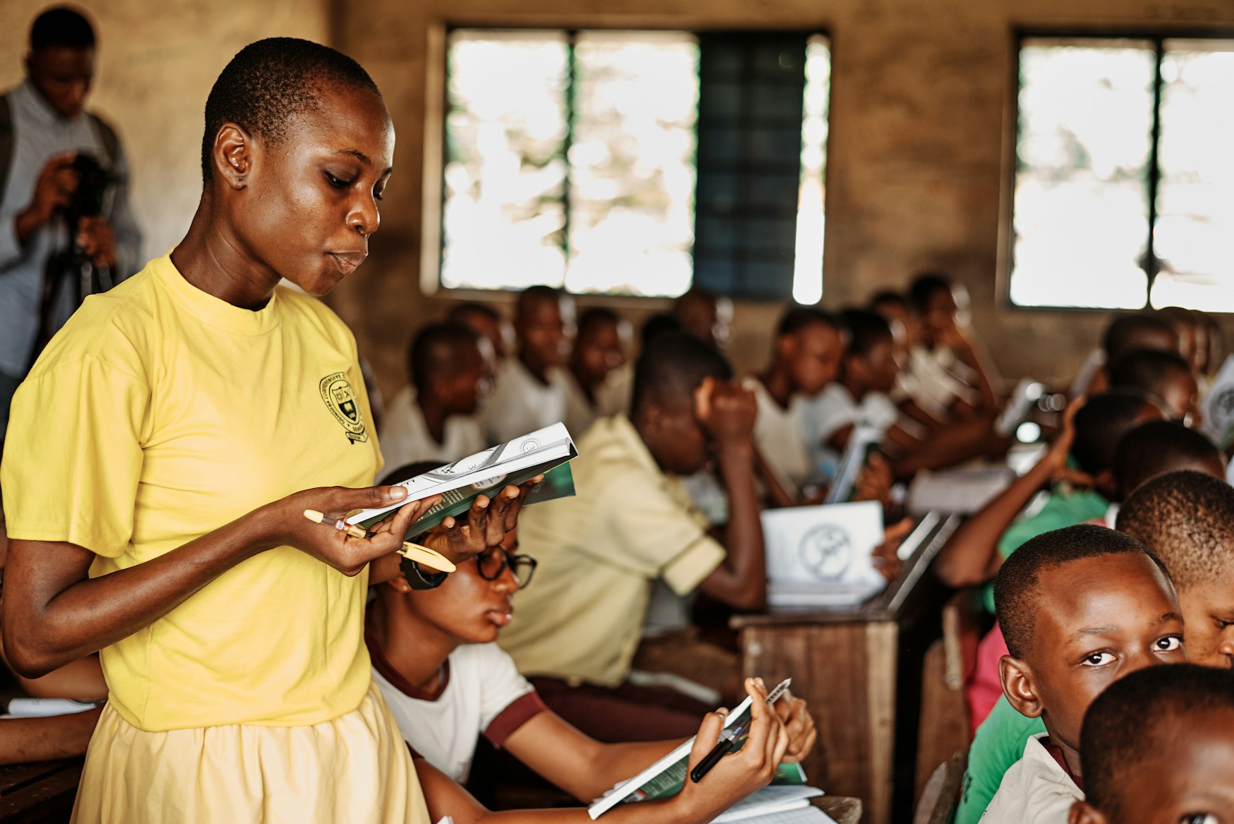 A teacher reads with pupils in a classroom